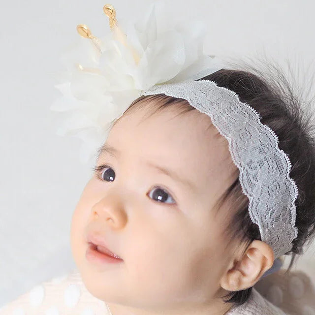 戴上皇冠蕾絲髮帶後，呈現小公主般精緻造型之嬰兒。